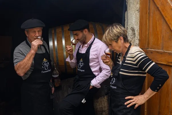 Dégustation à la Ferme de Gagnet, verres levés devant un fût